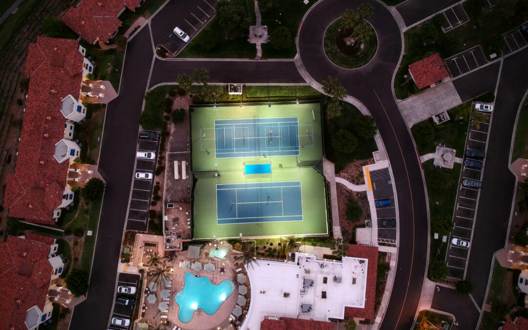 Aerial view of a pickleball court next to homes and businesses